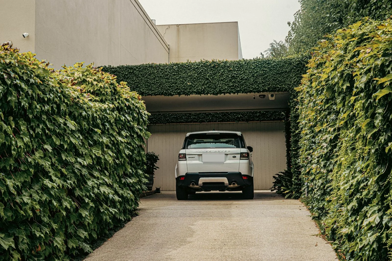A white SUV parked in the driveway of a modern home