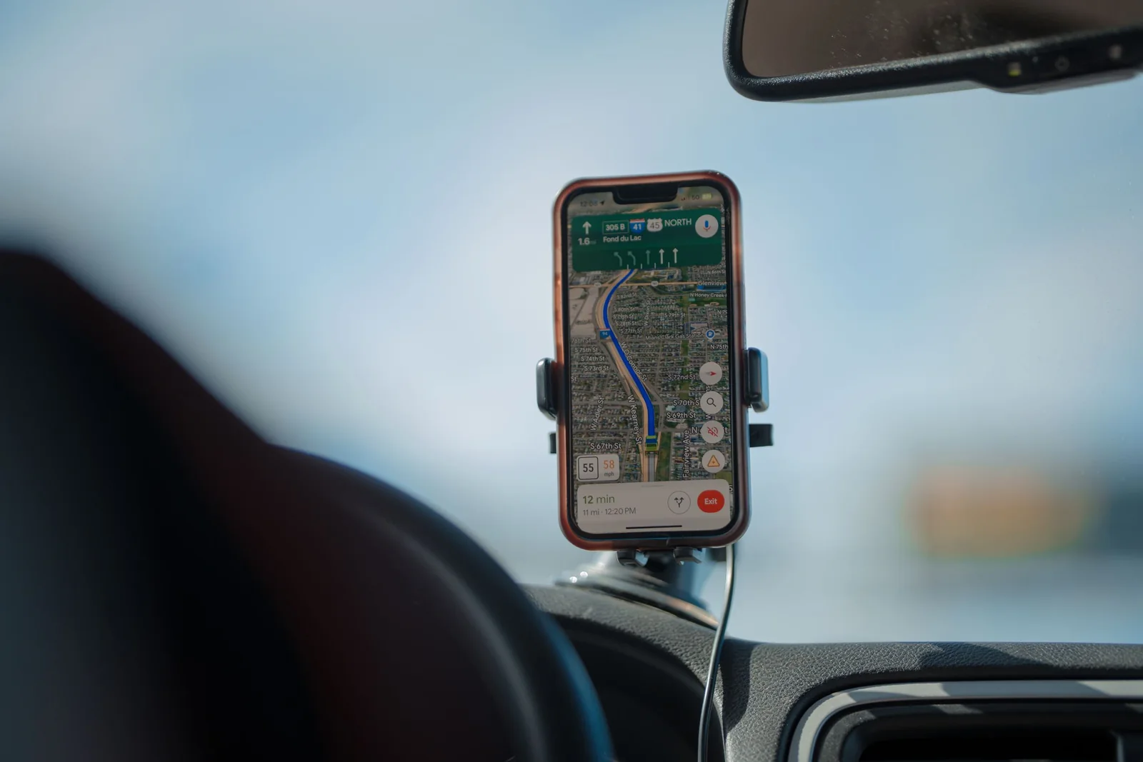 A phone showing a map on a car dashboard
