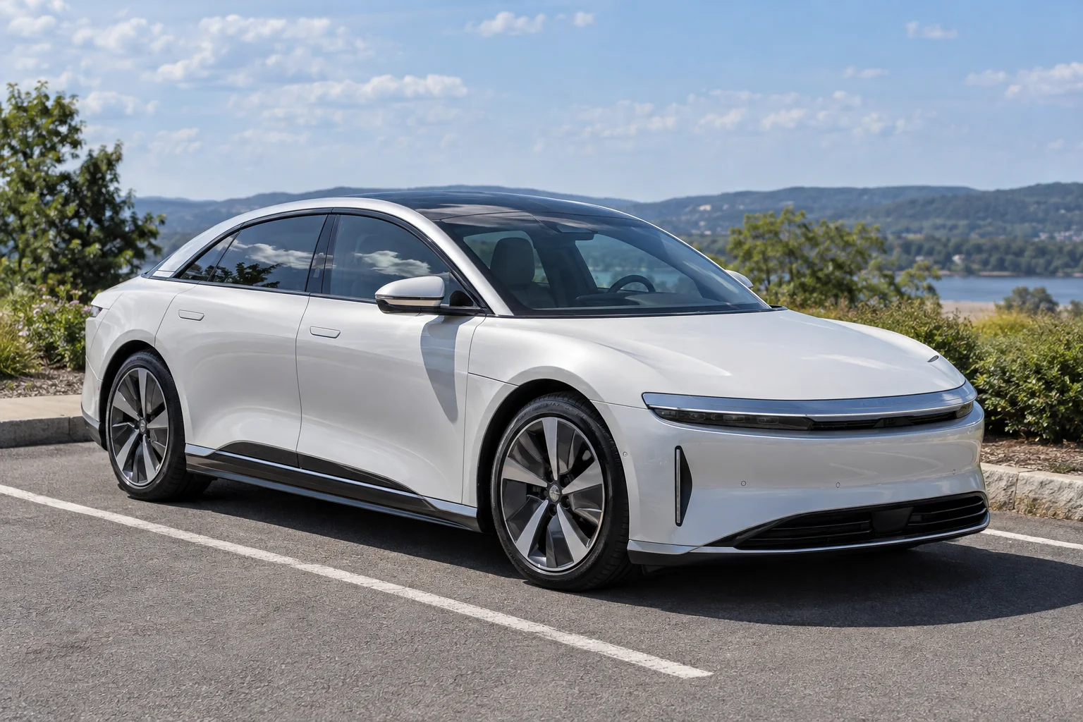 A white Lucid Air with a light tint parked in the sun