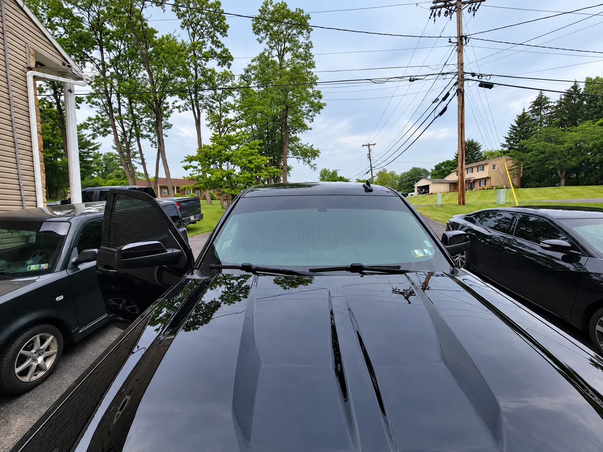 A black car parked on a driveway after window tinting