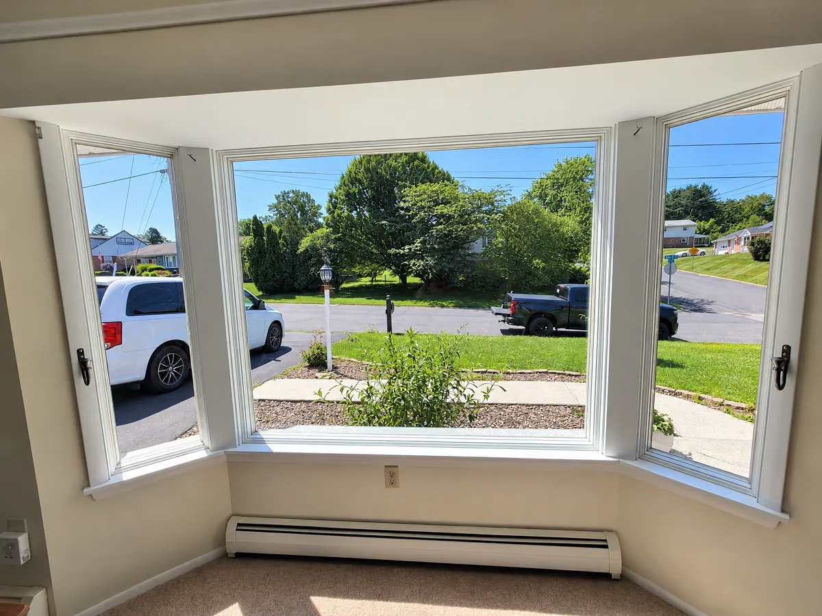 A living room bay window with window film, looking out to the street